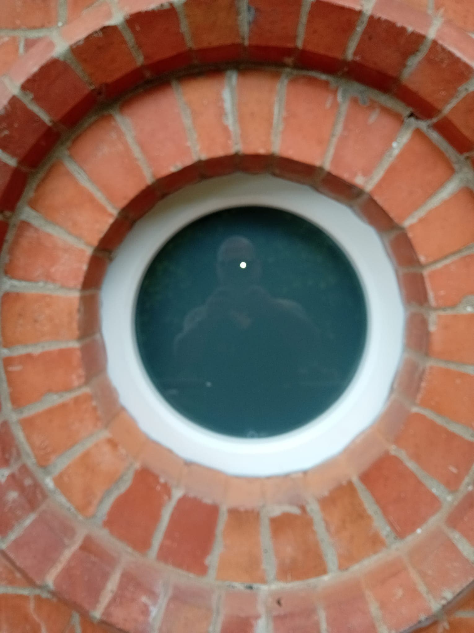 Completed circular window installation with white painted wooden frame